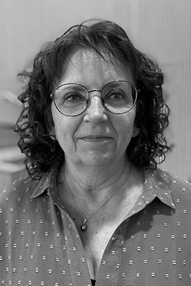 Sort-hvidt portræt af kvinde med runde briller Sort-hvidt portræt af en kvinde med krøllet hår, runde briller og en mønstret skjorte.