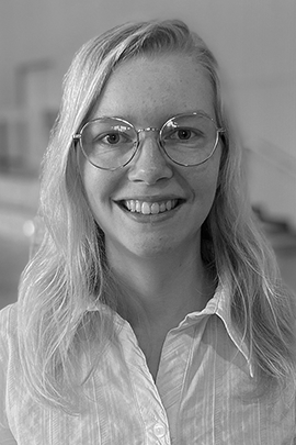 Sort-hvidt portræt af kvinde med briller Smilende kvinde med langt lyst hår og runde briller i sort-hvidt portræt.