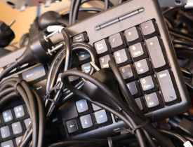 Bunke af sammenfiltrede tastaturer og kabler.