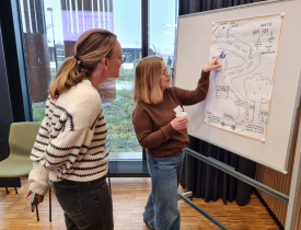 To deltagere fra Projekt- og porteføljenetværket står og kigger på en tegning.