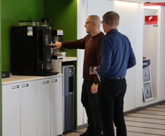 To medarbejdere fra SDU IT står ved en kaffemaskine.
