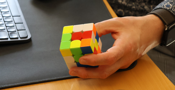 Hånd med en farverig rubiks terning.