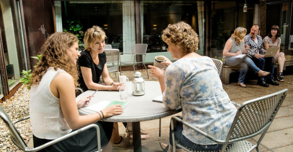 To grupper af mennesker sidder og snakker. 