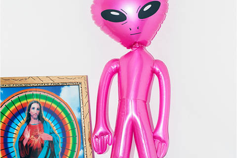 Image of an inflatable alien and a picture of Jesus side by side